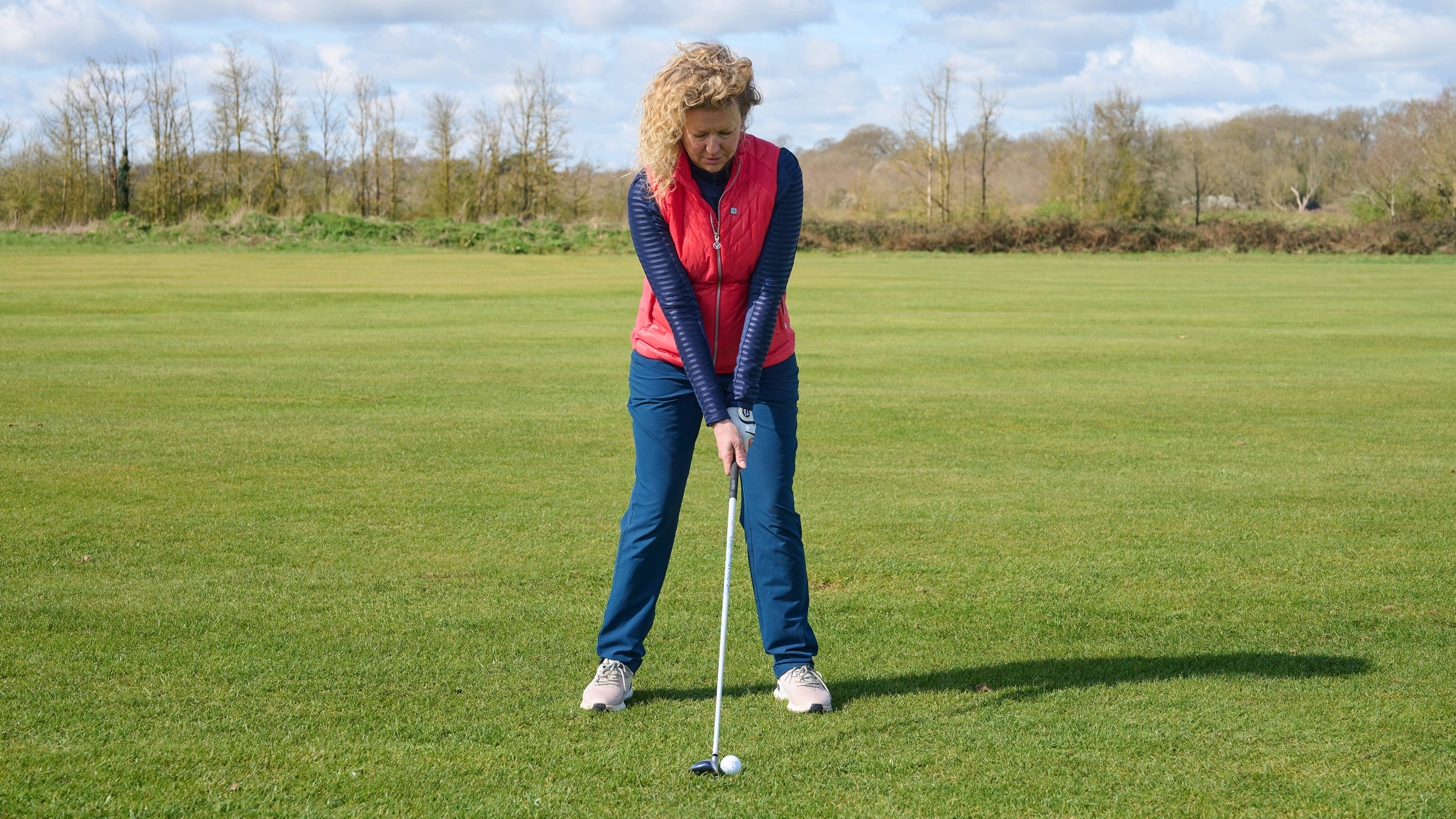 Katie Dawkins showing ball placement with a hybrid off the fairway