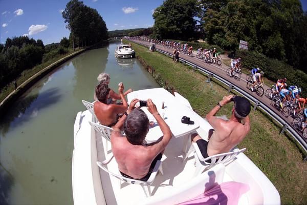 Spectators take in the sun and the Tour along the race route to Vittel.