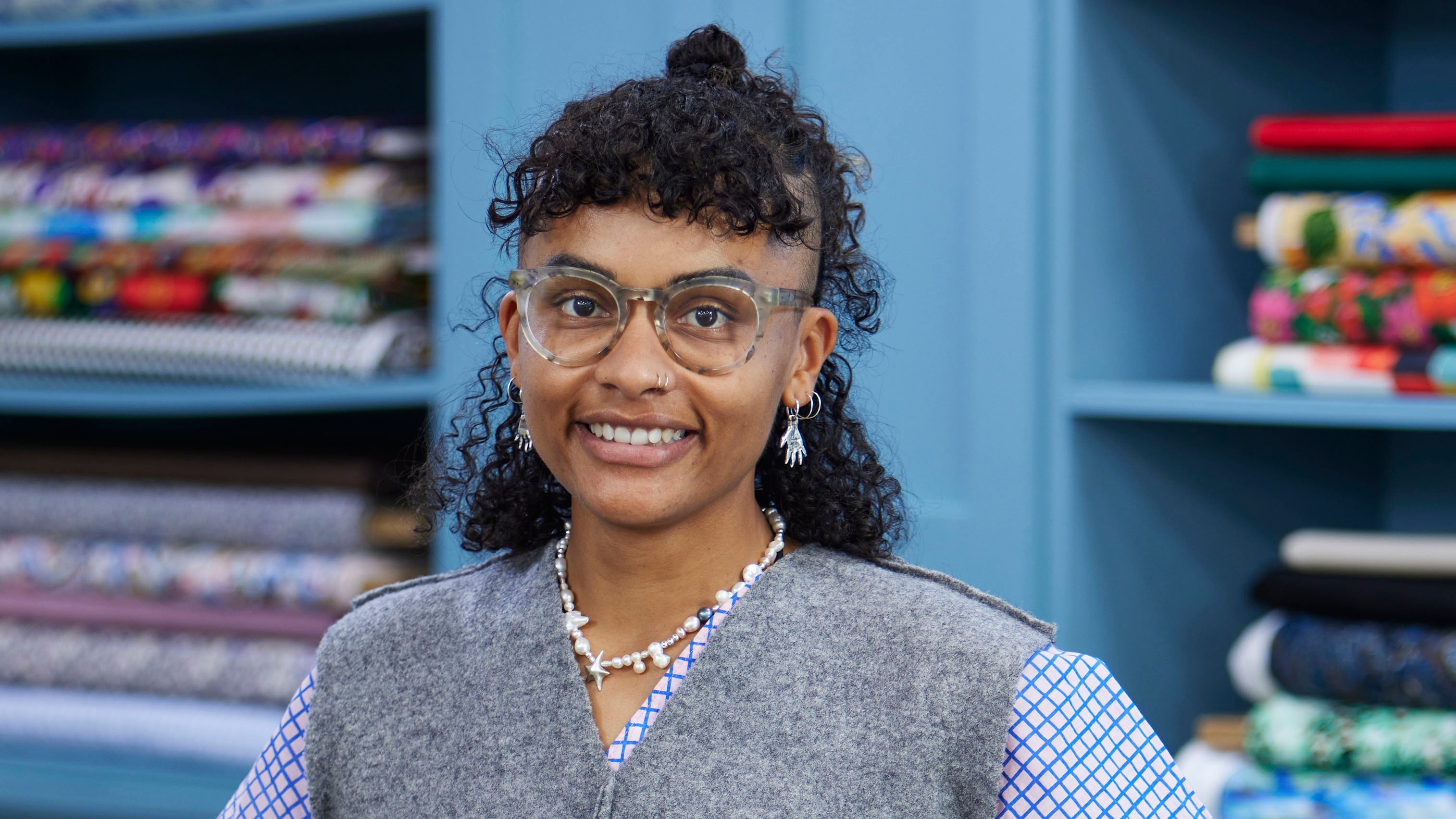 Saffie standing in the Great British Sewing Bee studio and smiling for the camera