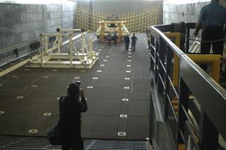 The Orion test article, a boilerplate version of the spacecraft with an unfinished interior, is seen in the well deck of the USS Anchorage. During recovery tests, the rear of the ship opened and allowed seawater to flood the well-deck area. The capsule was then floated out into the sea and recovered by Navy divers and smaller boats.