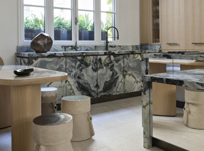 A kitchen with marble counter and island