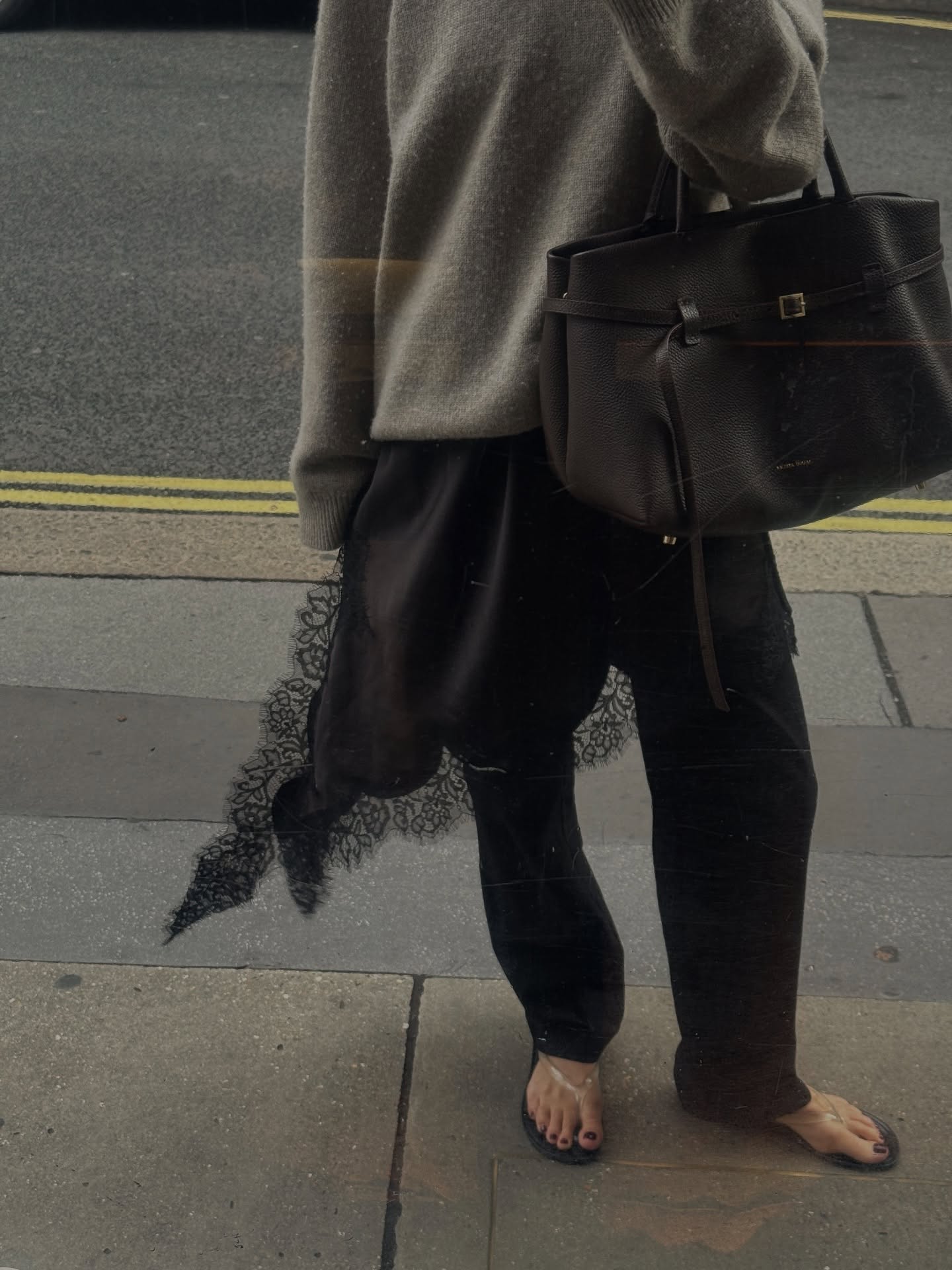 An image of @hannahlewisstylist wearing a cashmere jumper, Manu Atelier bag, lace trim and flip-flops.