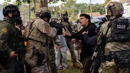 Federal agents point a weapon at protestors in Chicago