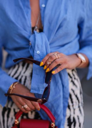 Nina Suess wearing blue Zara shirt, black and white Jacquemus skirt and red Louis Vuitton leather bag on June 16, 2021 in Berlin, Germany.