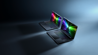 Två stycken Razer Blade-laptops står bredvid varandra mot en blå/svart bakgrund.