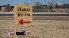 A sign points to measles testing facilities in Seminole, Texas. 
