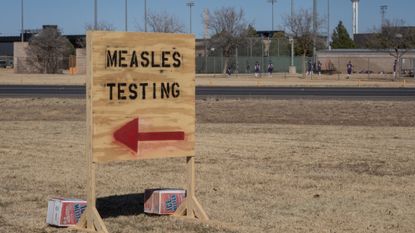 A sign points to measles testing facilities in Seminole, Texas. 