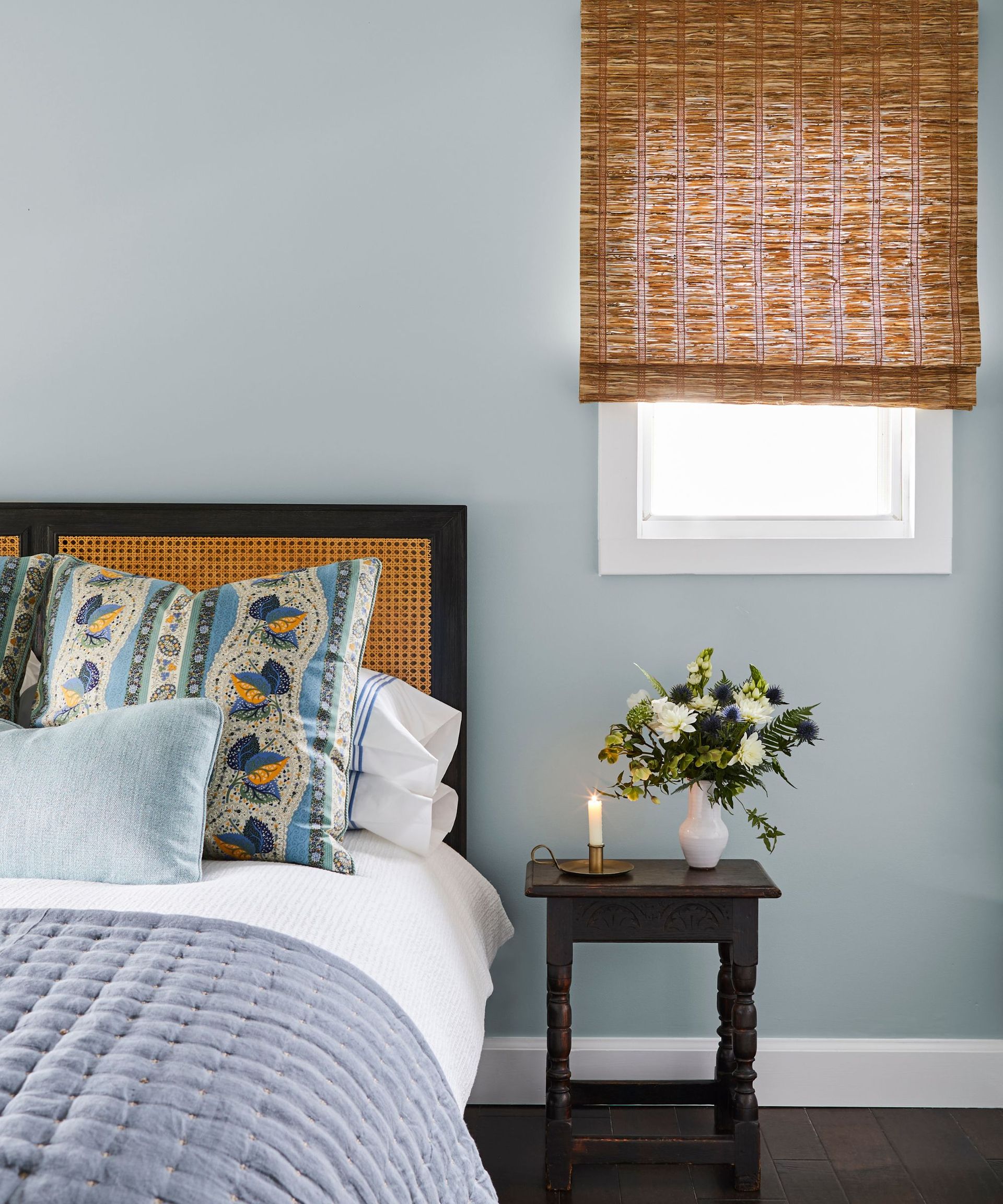 bedroom with pale blue walls and rattan blinds