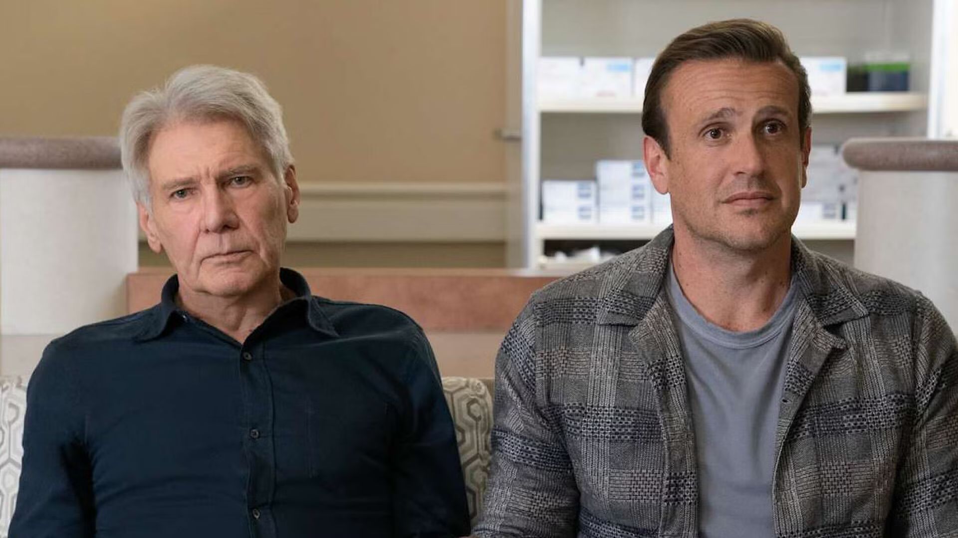 Harrison Ford and Jason Segal sit next to each other on a couch
