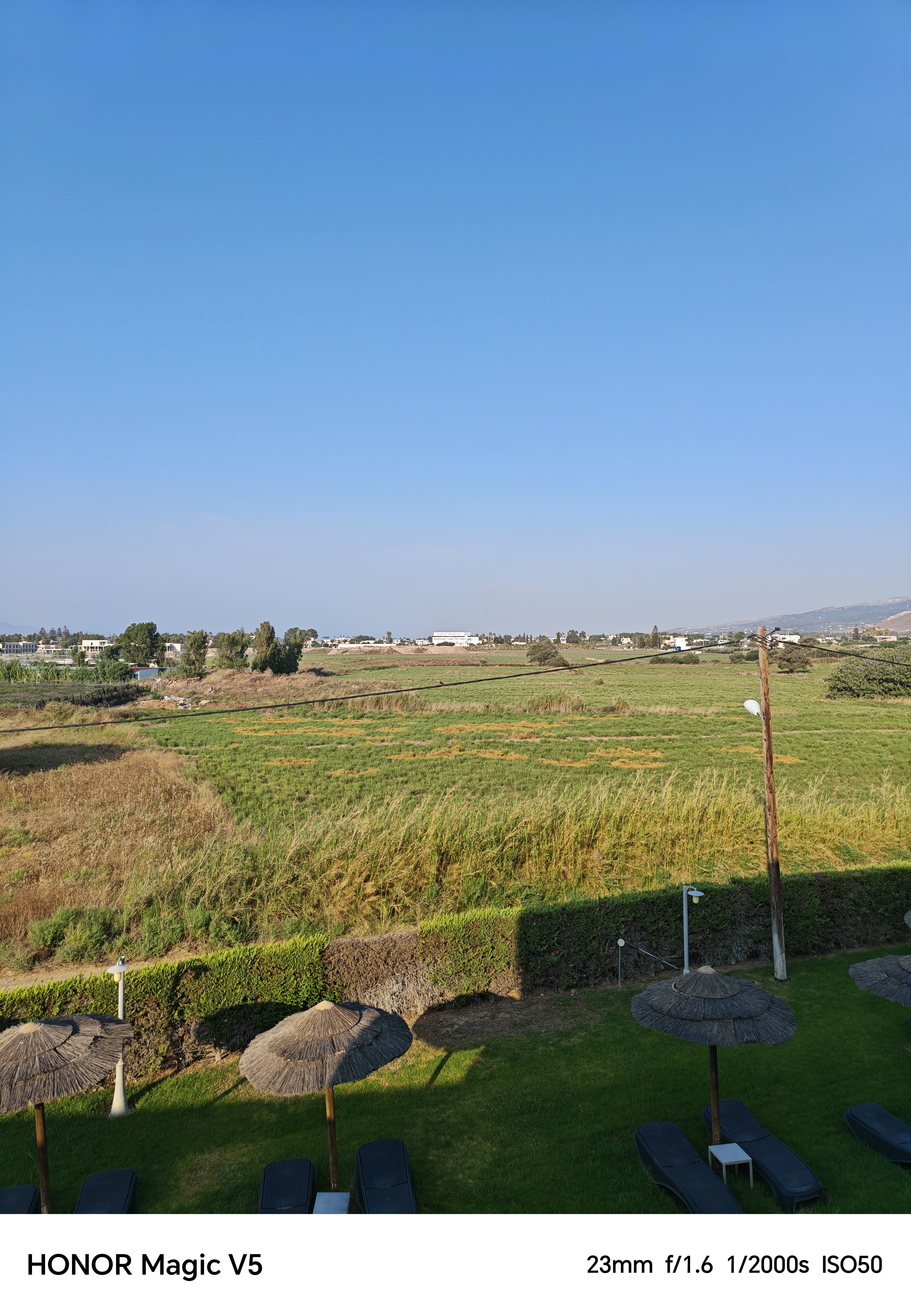 Green fields with a supermarket in the background