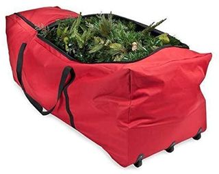 A Tree Keeper branded red Christmas tree bag on wheels with dismantled Christmas tree