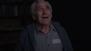 James Whitmore smiles while standing in the library in The Shawshank Redemption.