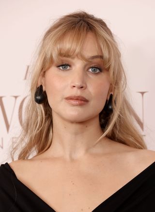 A photo of Jennifer Lawrence pairing her pregnancy bangs with a set of orb-like matte black earrings.