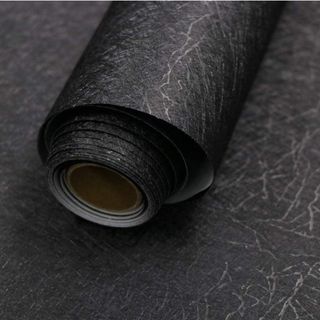 A roll of black textured peel and stick wallpaper