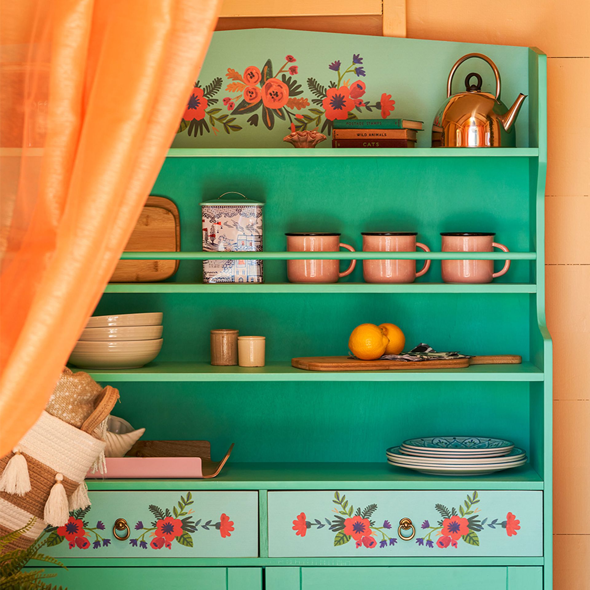 Plażowa chatka w kolorze pomarańczowym z zieloną kwiecistą komodą