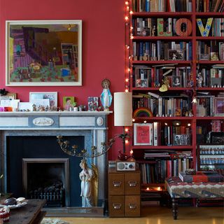 living room with fire place pink wall book shelve and painting frame