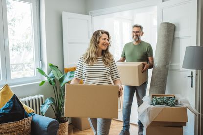 Mature couple moves in to their new home, unpacking boxes and enjoying the time together.