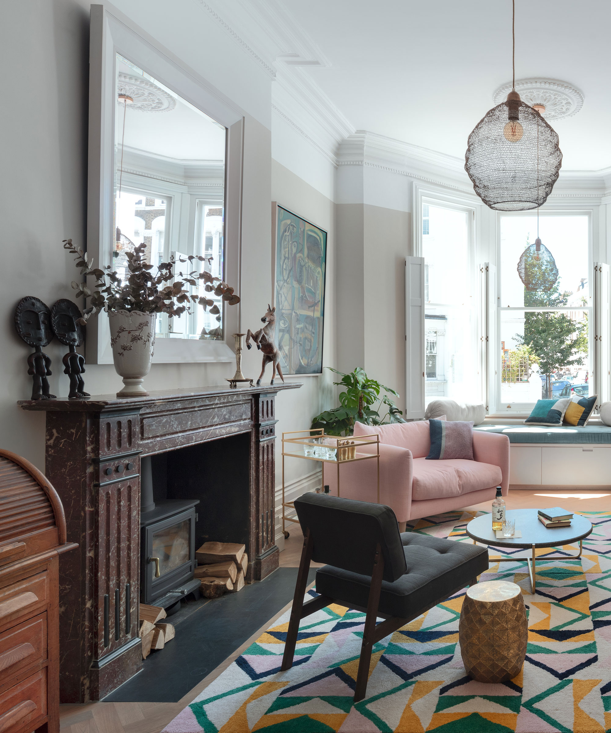 living room with dark marble fireplace and bay window with window seat