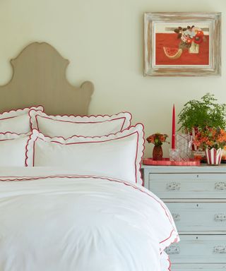 bed made with white bed linen with red edging