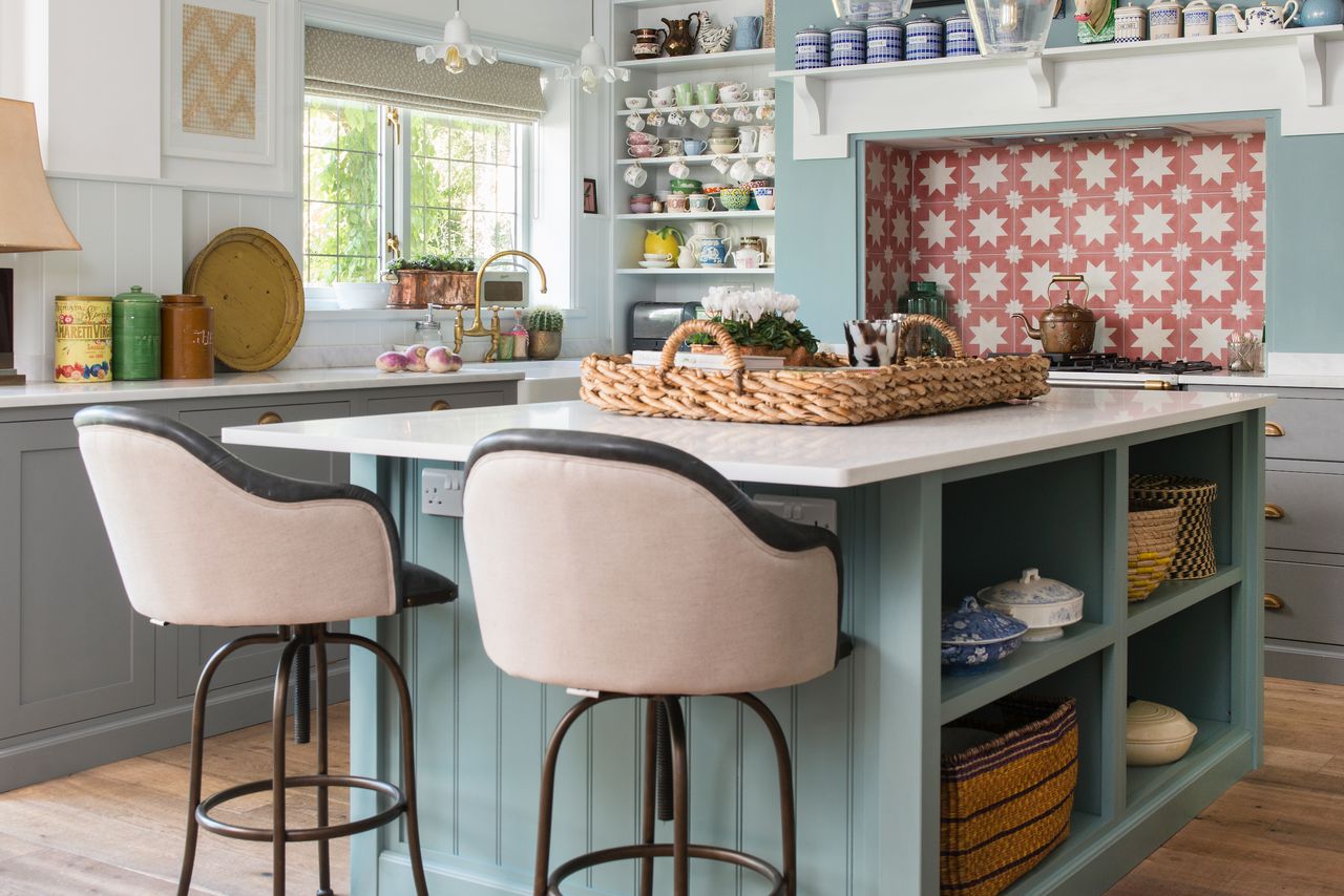 blue kitchen with pink bar chairs at island