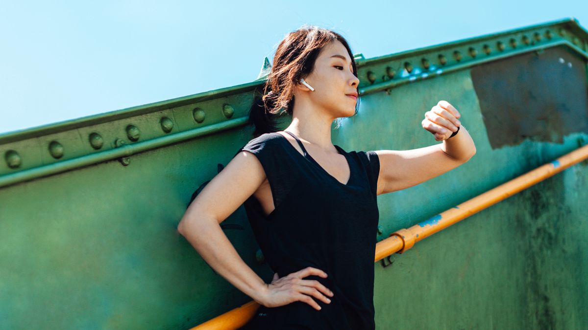 Young woman checking sports watch