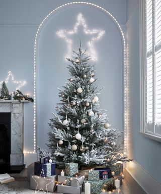 An oversized star tree topper on Christmas tree in living room