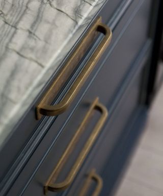 Brass cabinet handle on blue cabinet