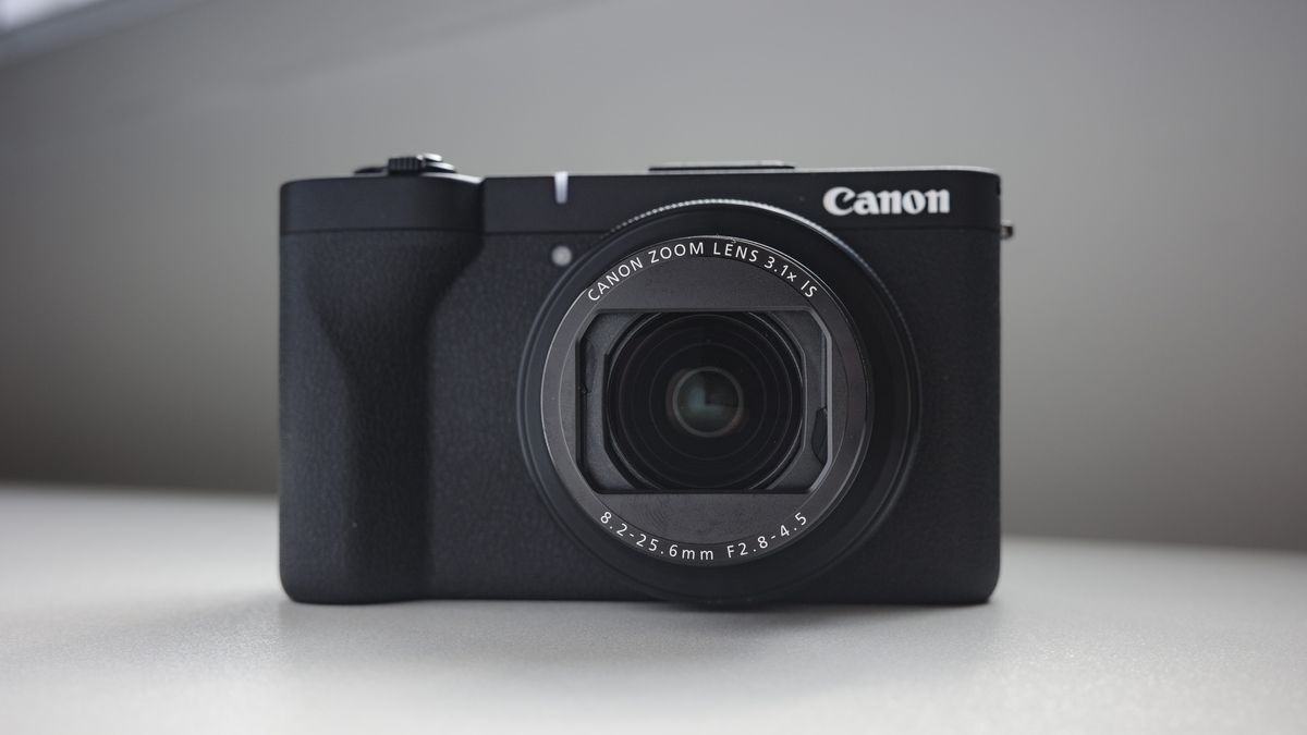 Canon PowerShot V1 compact vlogging camera on a white desk, lens extended