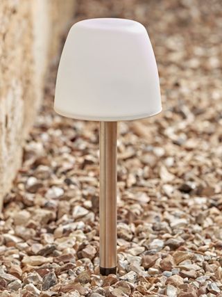 Frosted solar stake light standing on stones