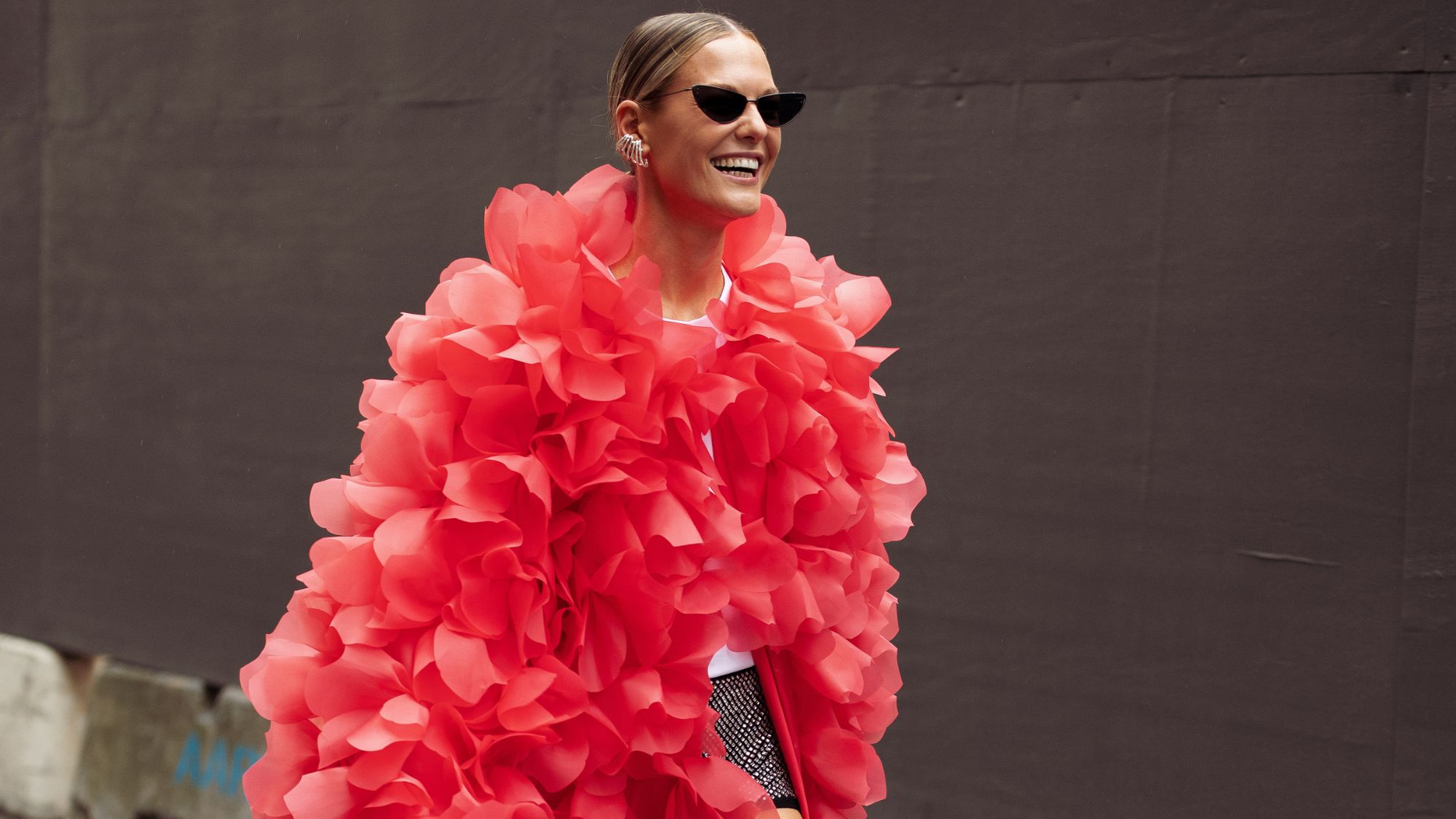 a model wearing a dramatic bright coat
