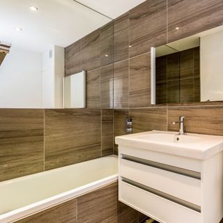 knappings barn bathroom with wall hung units and wood effect tiles on walls and floors