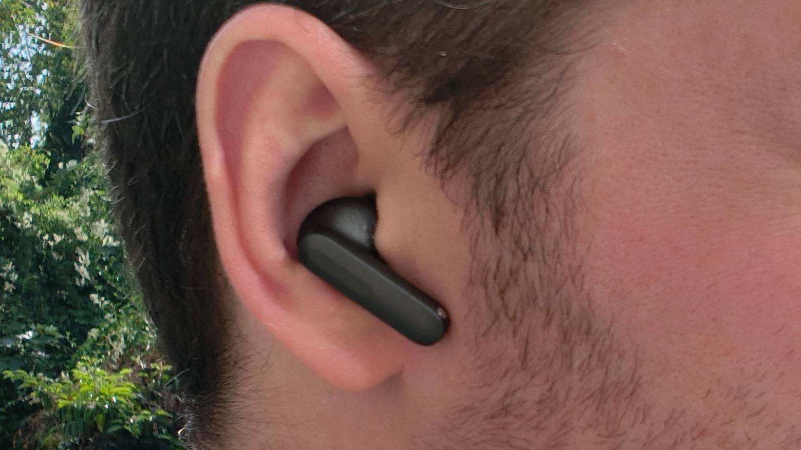 The OnePlus Buds 4in a man's ear.