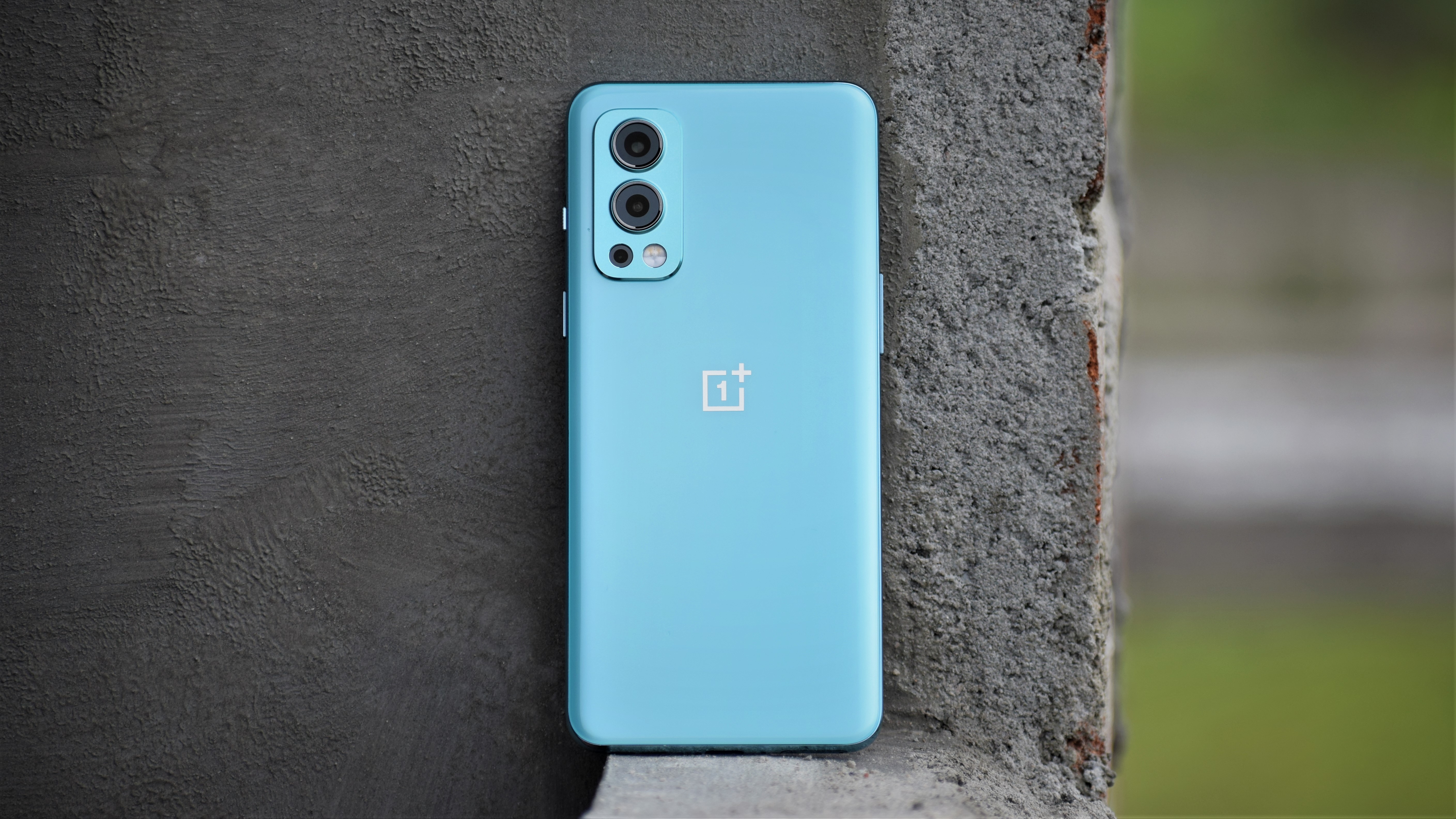 The OnePlus Nord 2 shown from the back, resting against a wall