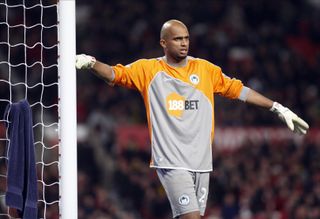 Goalkeeper Ali Al-Habsi leans on the goalpost while playing for Wigan Athletic against Manchester United, 2010