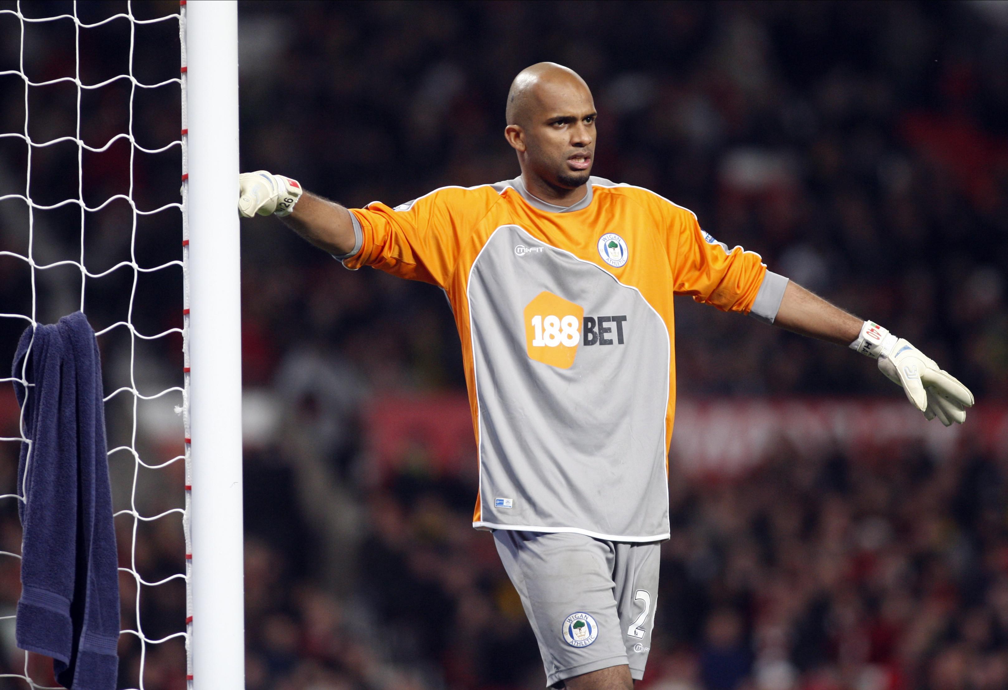 Goalkeeper Ali Al-Habsi leans on the goalpost while playing for Wigan Athletic against Manchester United, 2010