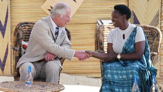 Prince Charles, Prince of Wales listens during his visit to the Mbyo reconciliation village