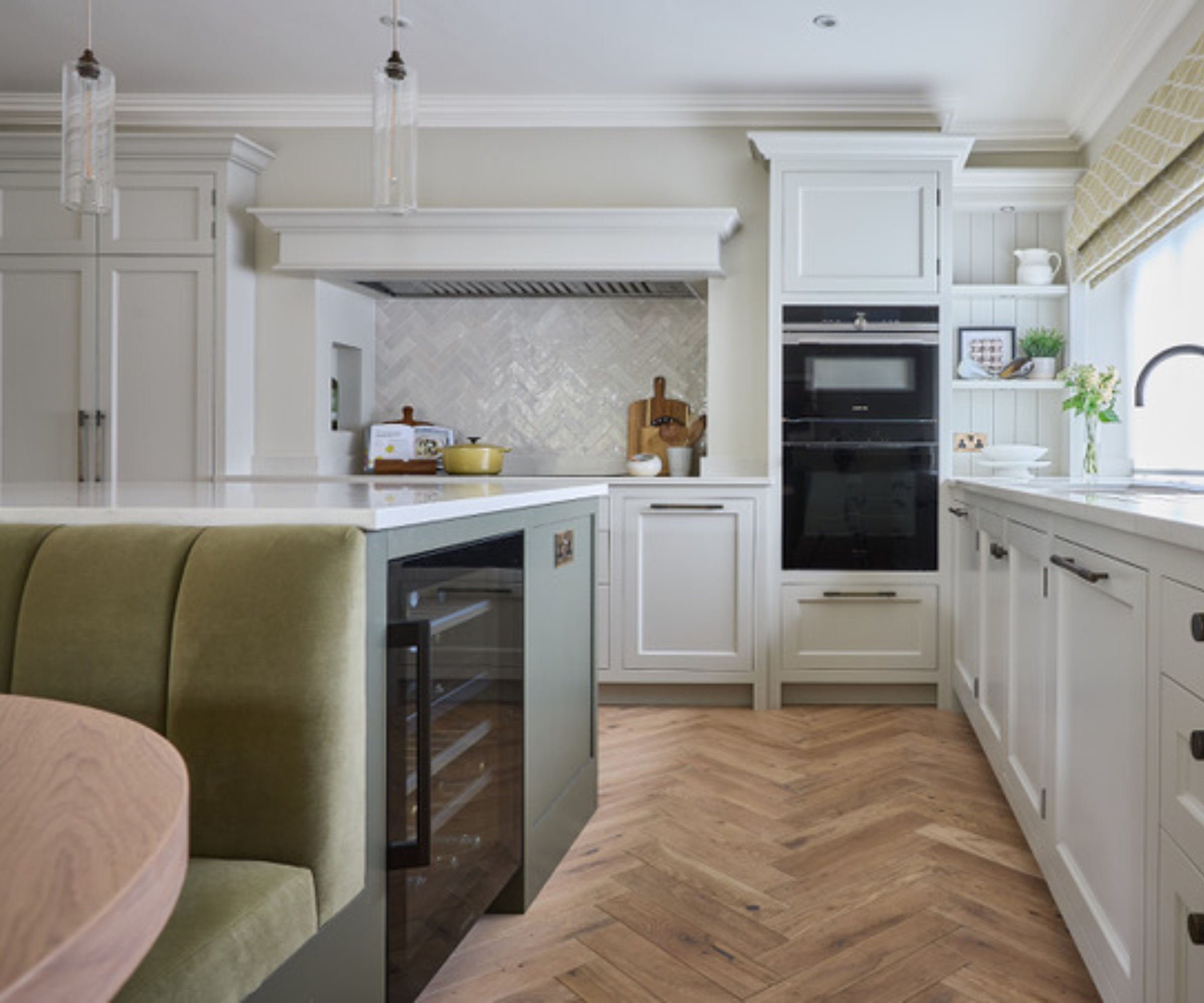Green and white kitchen with island bar fridge and parquet floors