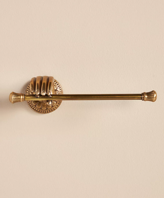 gold toilet paper holder with intricate hand detail