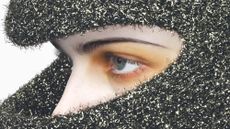 Model's made-up face seen beneath silver hood in image from Alex Black's book Scripted