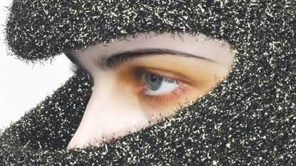 Model's made-up face seen beneath silver hood in image from Alex Black's book Scripted