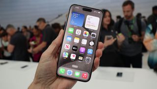 iPhone 15 Pro Max hålls upp i en hand under ett lanseringsevent.