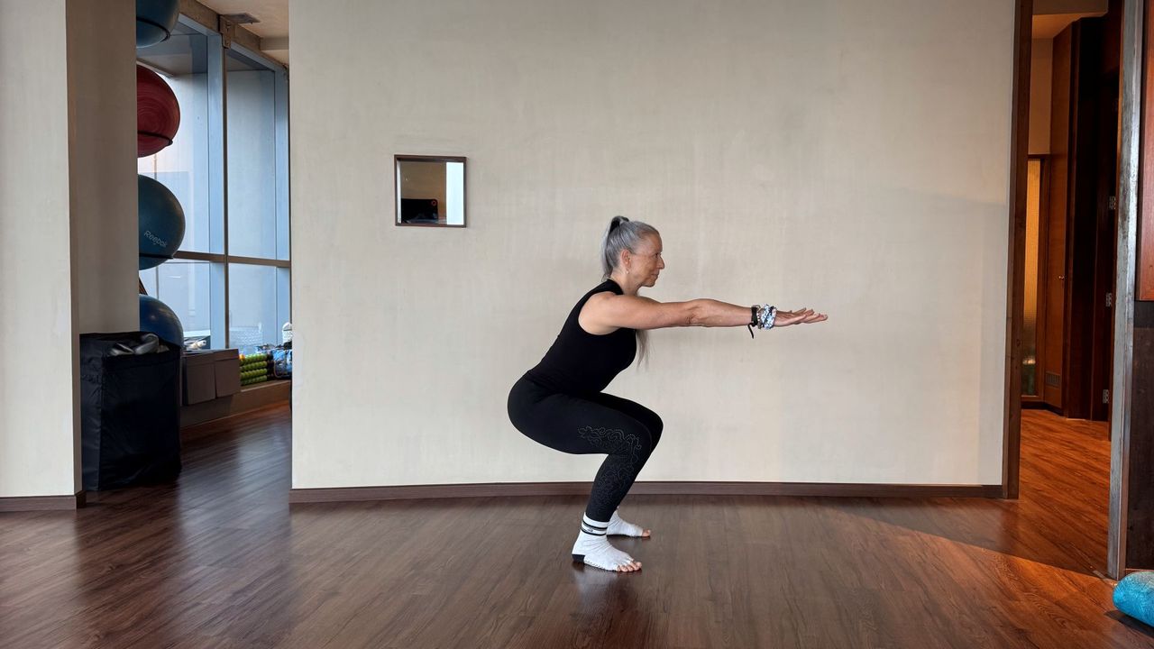 Woman demonstrates exercise in fitness studio