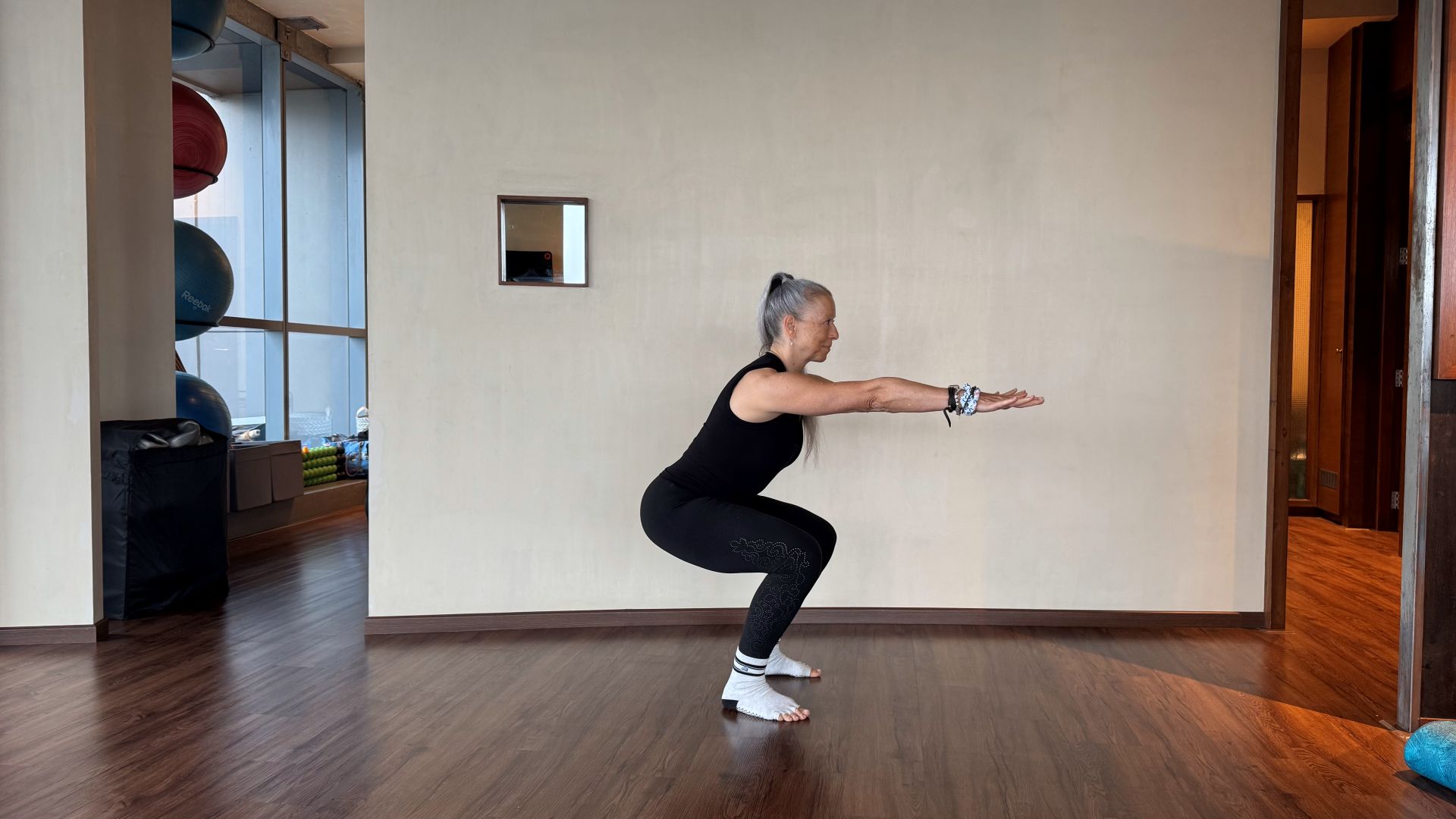 Woman demonstrates exercise in fitness studio