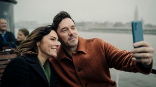 Annabel Scholey as Charlotte and Sam Palladio as Jacob posing for a selfie in a scene from 'The Couple Next Door' season 2.