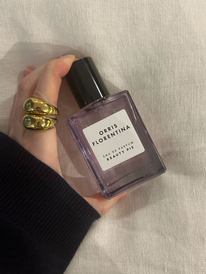 Junior beauty editor Grace Lindsay holding a Beauty Pie perfume on a white linen background