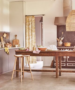 Pictures of kitchens showing a warm, wooden scheme with earthy tones in the cabinetry and soft furnishings, a wooden table and flooring.
