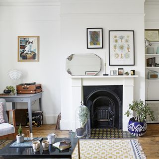 living room with white wall and fire place with mirror and plant on pot