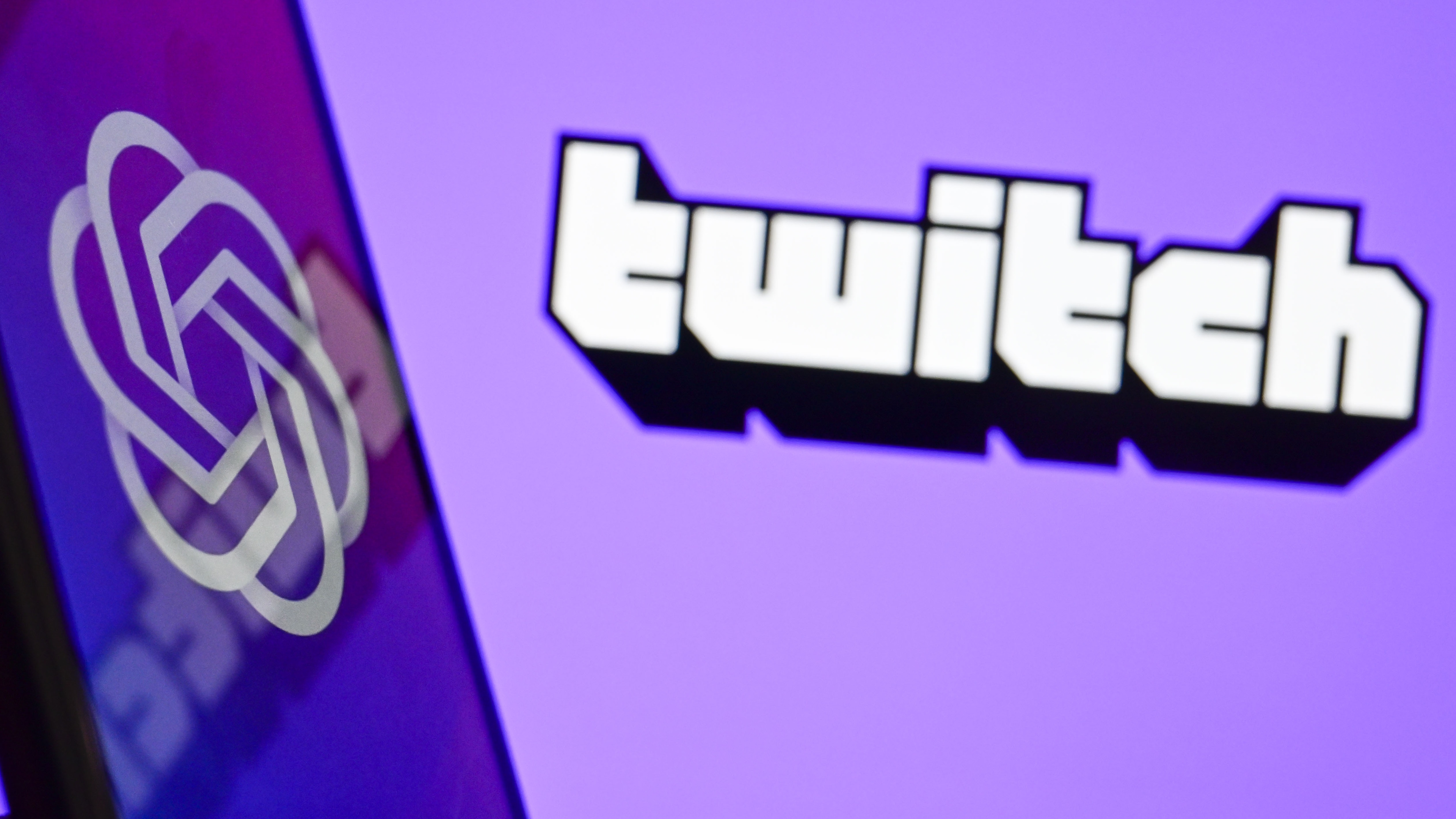 ANKARA, TURKIYE - NOVEMBER 21: In this photo illustration, OpenAI logo is displayed on a mobile phone screen in front of the logo of Twitch in Ankara, Turkiye on November 21, 2023. (Photo by Osmancan Gurdogan/Anadolu via Getty Images)