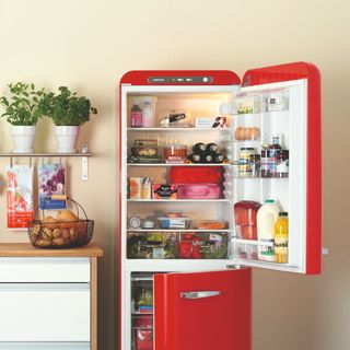 A kitchen with an open red fridge