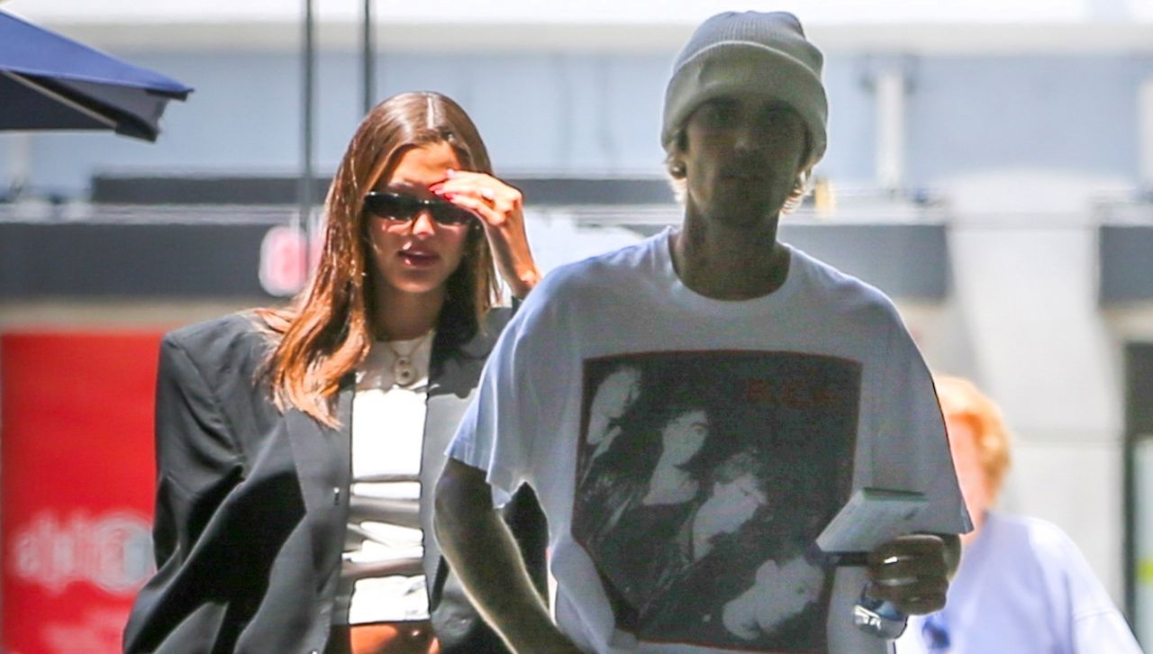 Hailey and Justin Bieber walk in Los Angeles while Hailey wears a cropped t shirt and suit